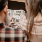A couple reminisces while looking through a family photo album, capturing warm memories indoors.